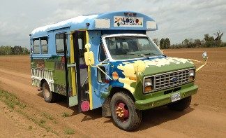 Photo of a truck with a color illustration on the exterior and wide windows.