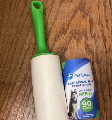 Figure 4. An extra sticky lint roller with a green handle beside an unopened refill roll.