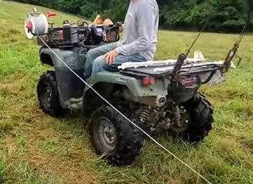 2c and 2d. An adjustable metal tube arm mounted on the front rack of this four- wheeler serves to hold a reel for hands-free unrolling of temporary wire.