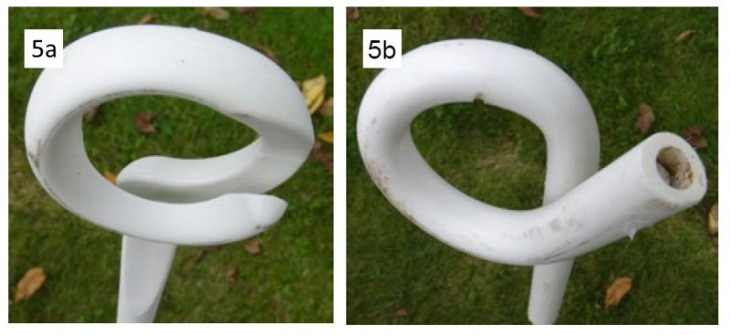A white post that curves at the top to form a circle; the tail at the end extends out a couple of inches, crossing over the post to create an upward handle. A gap between the tail and the post leaves a narrow opening to slide wire into the ring.