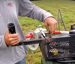 2c and 2d. An adjustable metal tube arm mounted on the front rack of this four- wheeler serves to hold a reel for hands-free unrolling of temporary wire.